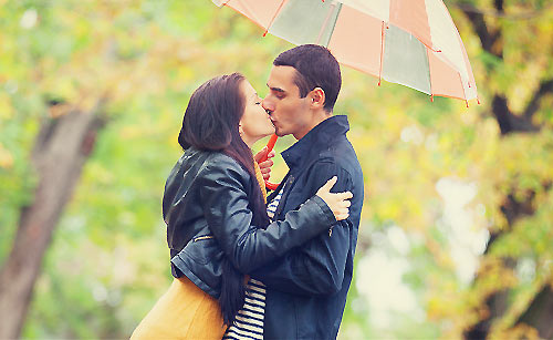 相合傘の中でキスをするカップル