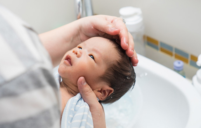 洗面台で赤ちゃんの体を洗う
