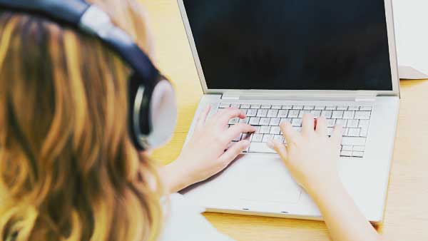 音楽を聴きながらパソコンを使う女性