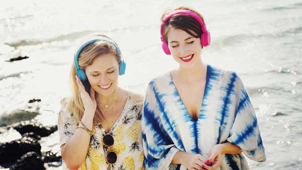 海辺で音楽を聴く女性