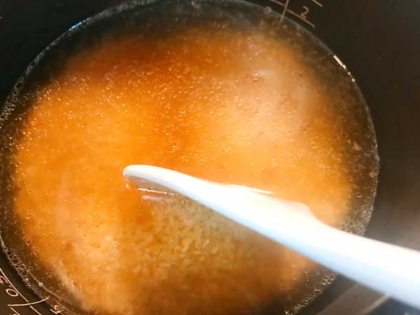 炊飯器に研いだ米と水とサンマ缶の汁を入れて混ぜ合わせた状態