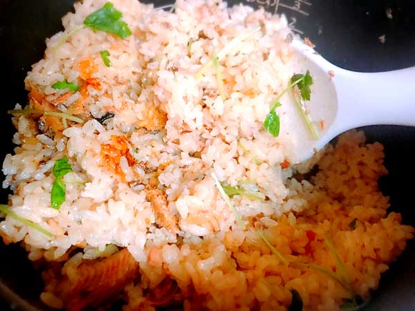 炊きあがった秋刀魚とカリカリ梅の本格炊き込みごはんを混ぜ合わせている状態