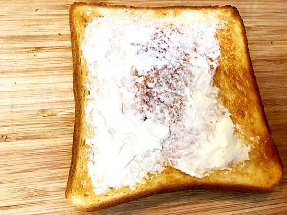 焼き上がったトーストにクリームチーズを塗った状態